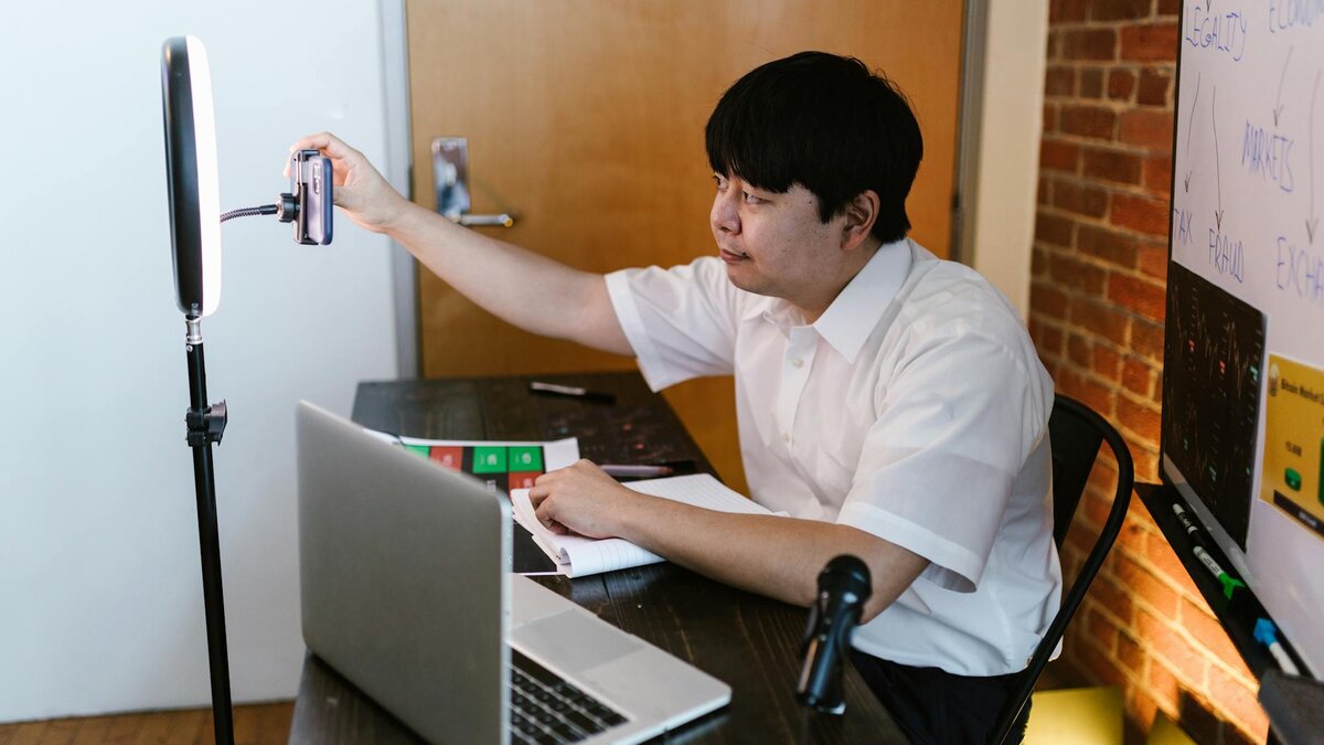 Creator setting up phone camera with ring light for educational YouTube video
